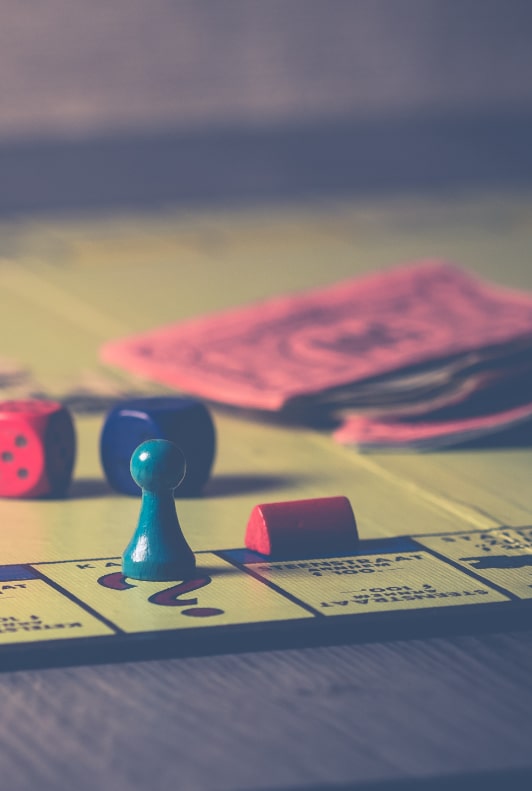 Ett foto på ett monopolbräde med en pjäs, tärningar och pengar