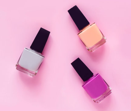 Bild på tre nagellack i trendiga färger mot rosa bagkrund